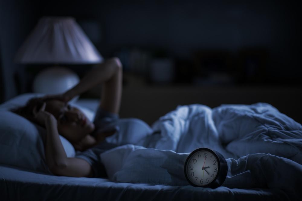 Mulher com dificuldade para dormir por conta de tratamento com medicamentos especiais.